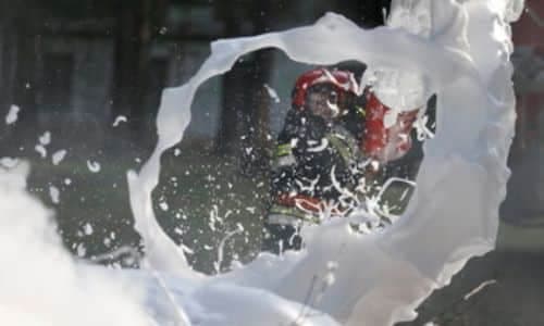 immagine di pompiere che estingue l'incendio con un estintore a schiuma