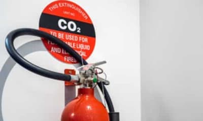 Immagine di un estintore co2 su una parete bianca e con il cartellino della descrizione
